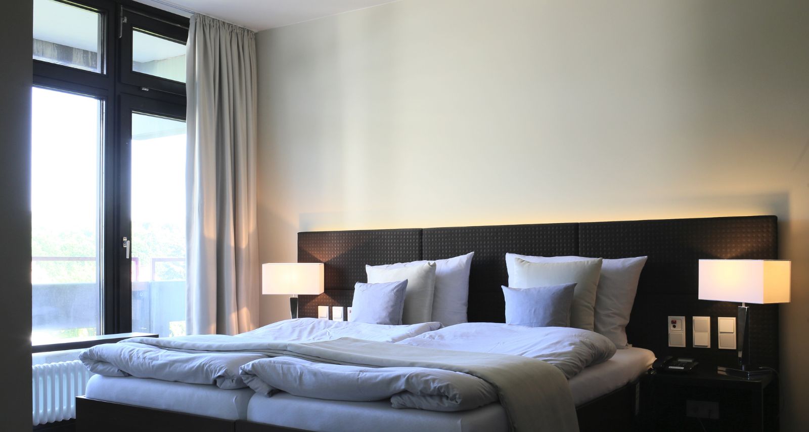 Doppelzimmer mit Komfortbett, Stehlampen, an der linken Seite sind die Fenster